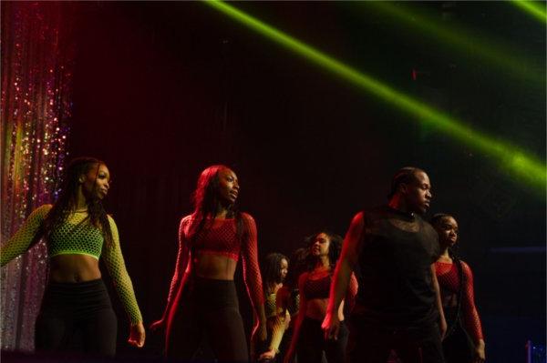 A group of dancers in neon-colored mesh shirts perform at Presidents&rsquo; Ball. 