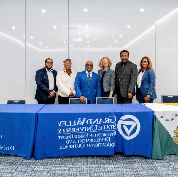 six people standing behind table